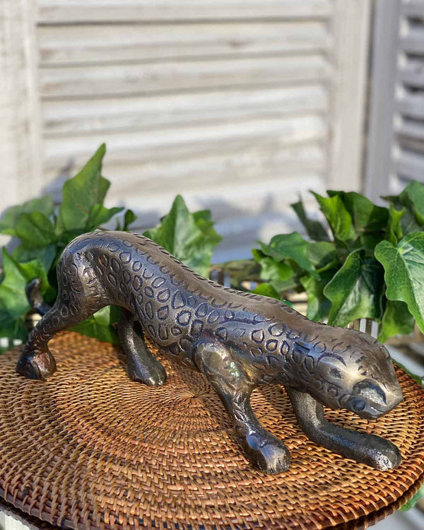Brass panther ornament on a rattan placemat.