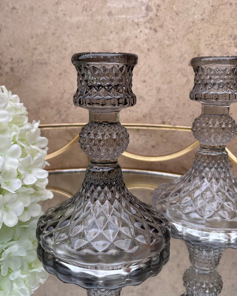 A pair of grey glass candlestick holders.
