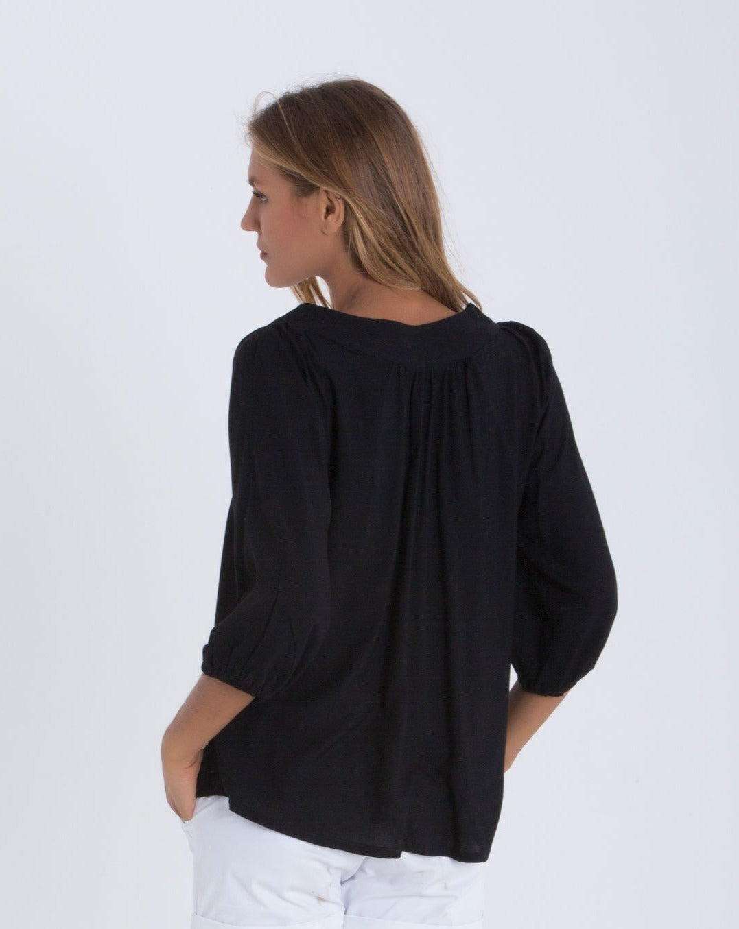 Back studio shot of woman in black blouse.