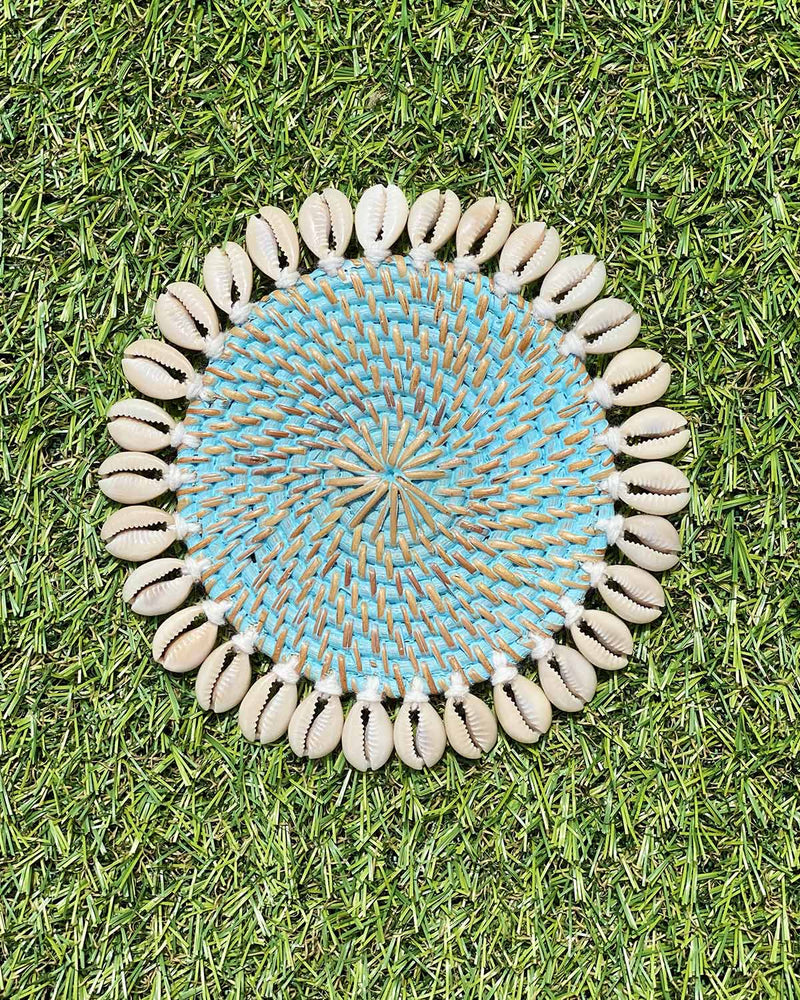 Rattan coaster painted turquoise edged with sea shells.