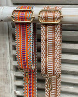 Two aztec bag straps one colourful aztec print and one with beige/cream aztec print.