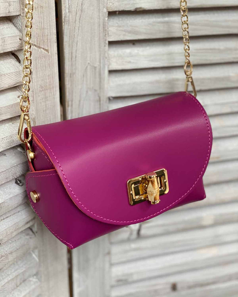 Fuchsia cross body bag with gold bamboo clasp. With attachable gold chain.
