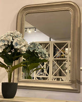 Large grey mirror with beaded detailing around the edge.