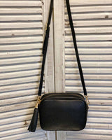 Black leather tassel bag with side tassel with adjustable long cross body strap.
