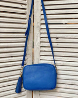 Cobalt leather tassel bag with side tassel with adjustable long cross body strap.