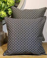 Two large cushions both printed in a black and white domino print.
