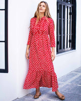 Woman wearing red and white netted ankle length print dress. With a collar and cuffed sleeves.