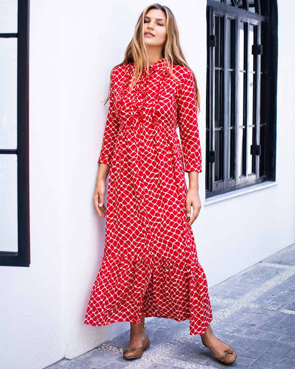 Woman wearing red and white netted ankle length print dress. With a collar and cuffed sleeves.