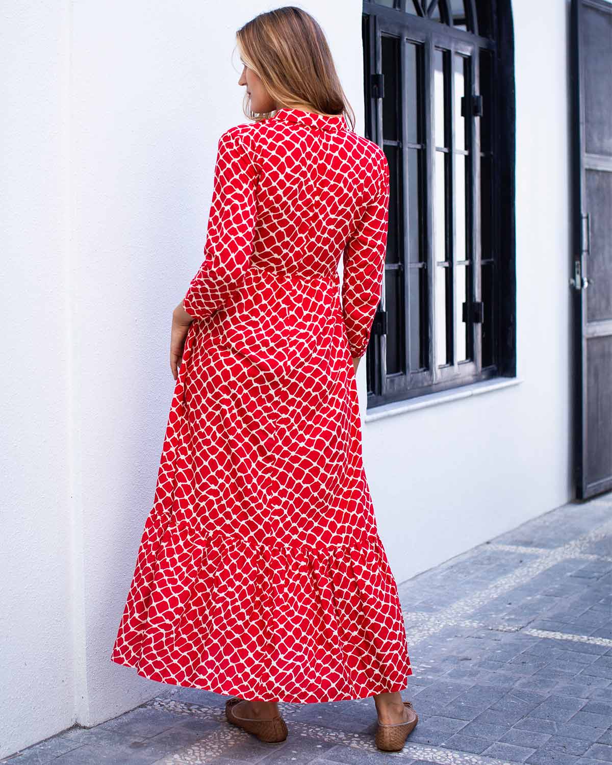 Woman wearing red and white netted ankle length print dress. With a collar and cuffed sleeves.