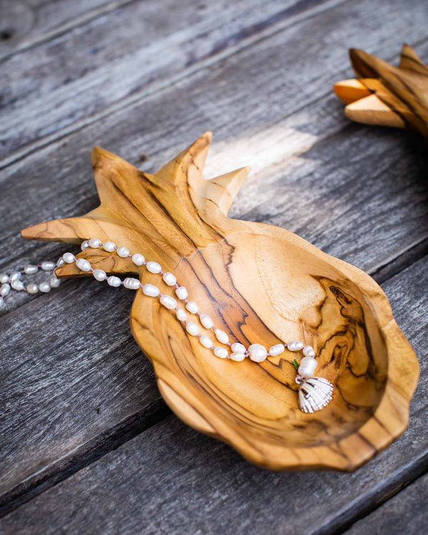 Wooden pineapple dish, holding a necklace.