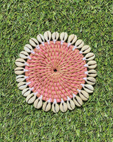 Rattan coaster painted pink edged with sea shells.
