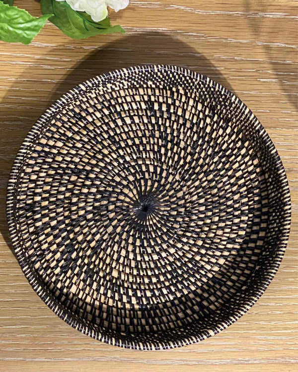 Woven black round rattan tray.