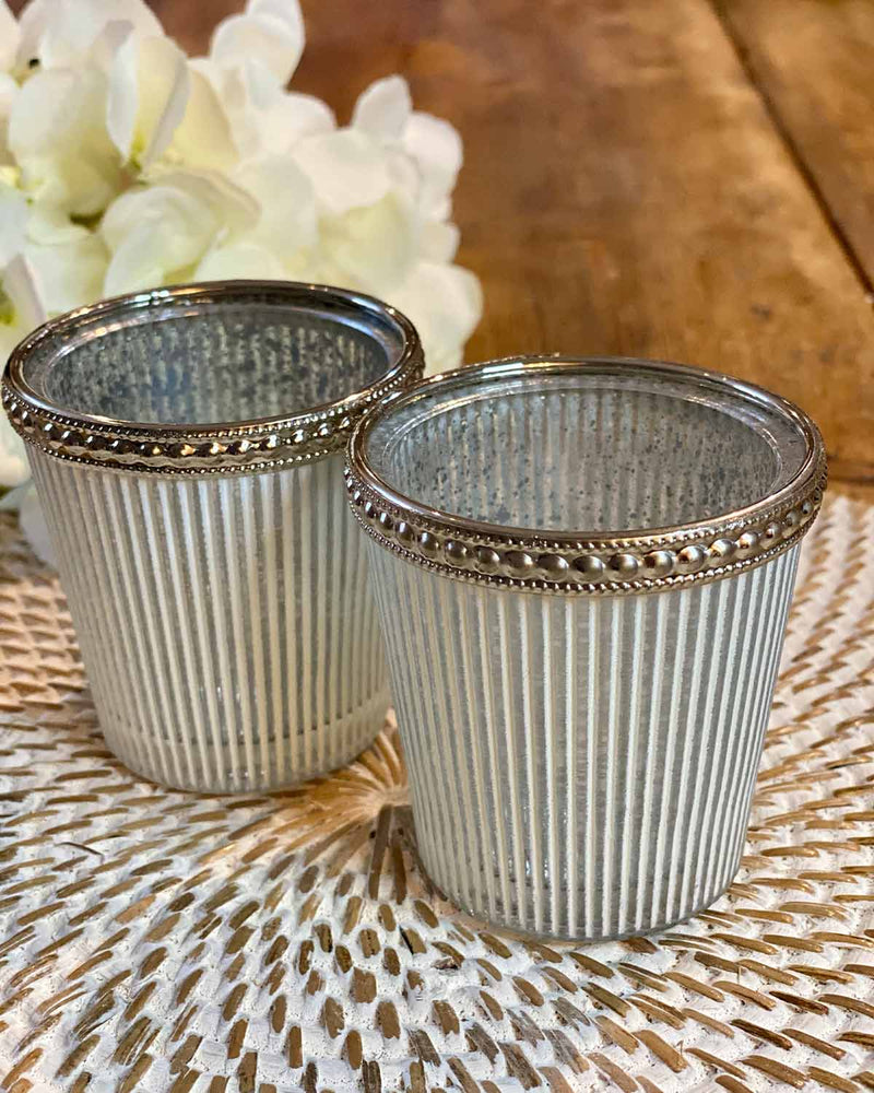 Two white and grey striped tea lights, edged in silver at the top. 