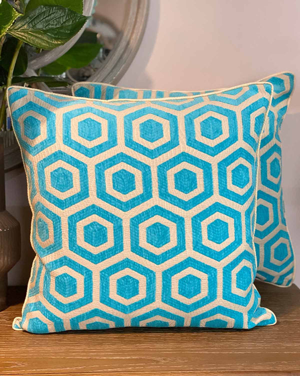 Two large cushion covers in turquoise and cream geometric print.