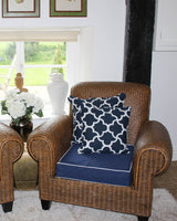 Black cotton cushion covers printed with a white clove print, pictured on a rattan chair.