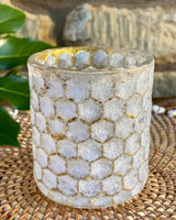 A honeycomb effect gold edged tea lights on a rattan placemat.