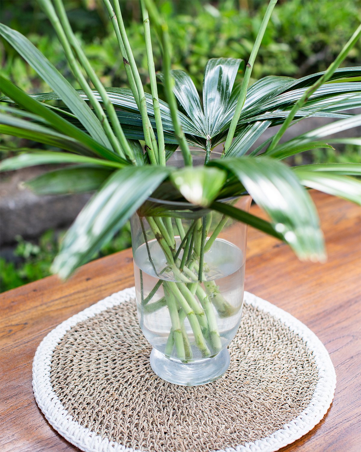 Woven placemat edged in white, pictured with an flower arrangement in the middle.