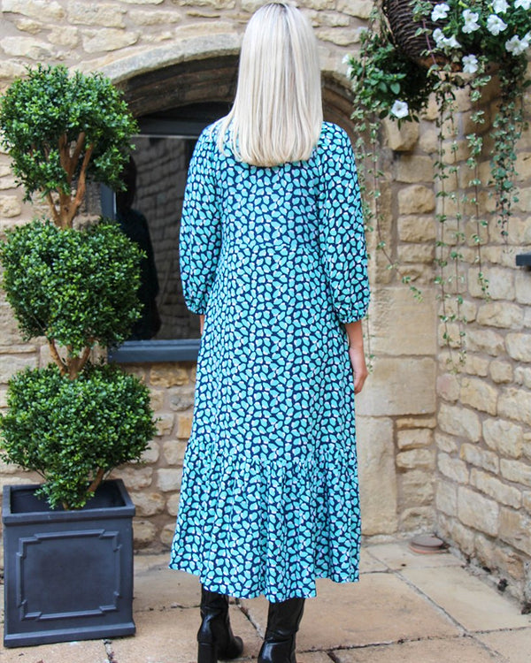 Women wearing green and blue geometric patterned ankle length dress tier bottom design with ¾ length sleeve.