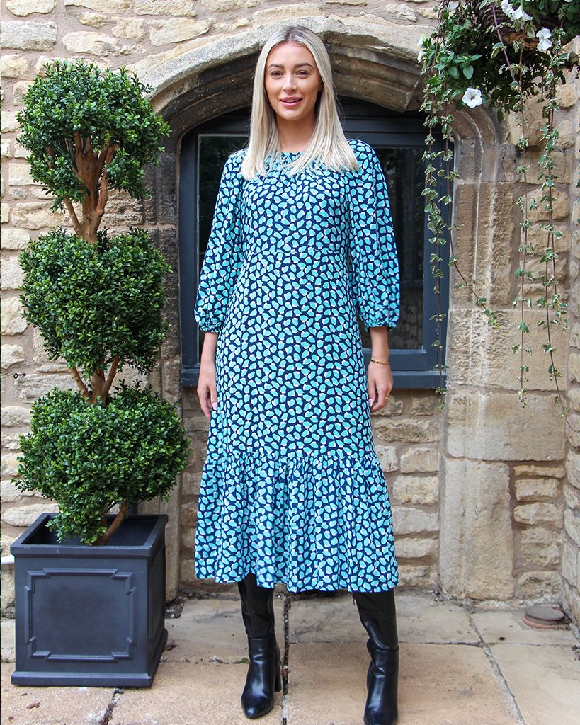 Women wearing green and blue geometric patterned ankle length dress tier bottom design with ¾ length sleeve.