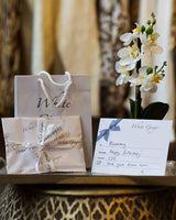 White Ginger branded gift voucher, wrapped like a present on a tray on a side table.